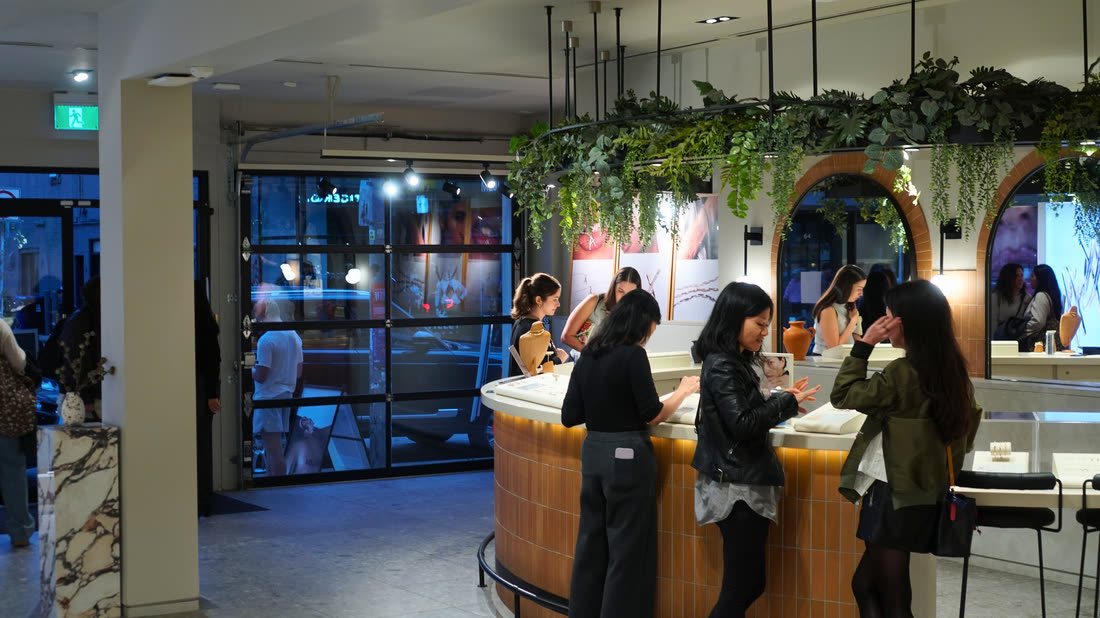 A bar set up inside the store, with bottles, cans, and glassware, and guests nearby.