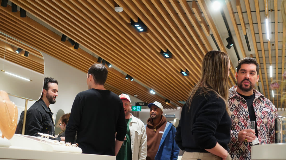 Guests gathered around the Shop & Sip sign inside the store.
